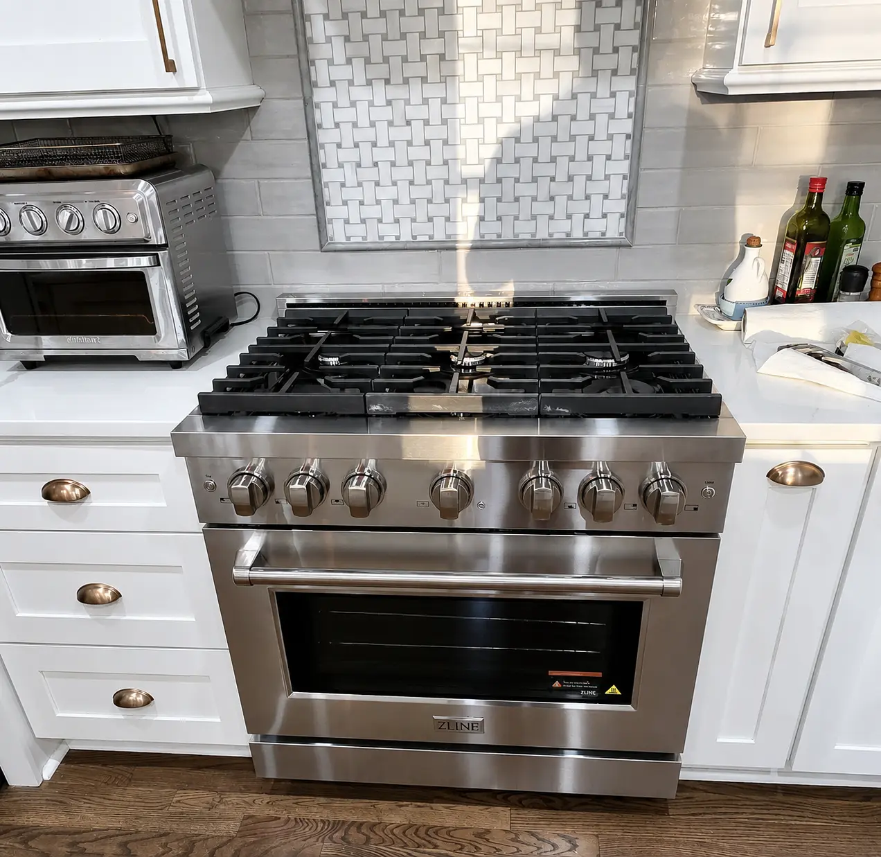 Professional gas range and oven installed in a modern kitchen with stainless steel appliances
