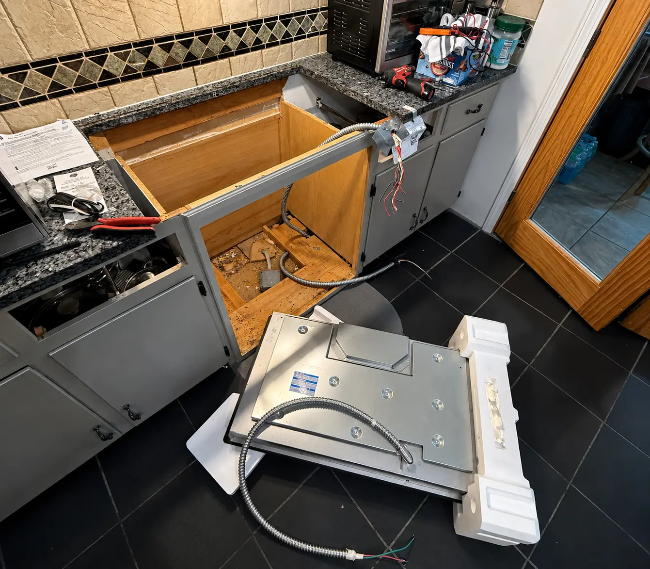 Technician installing a built-in kitchen appliance during a professional appliance installation service