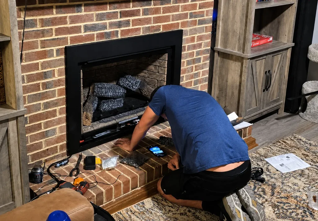 Technician repairing a gas fireplace during a professional fireplace maintenance and repair service